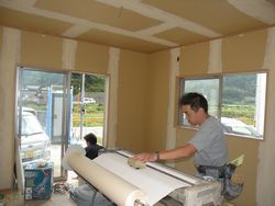 クロス張工事(機械を使ってクロスへのり付をしています。)